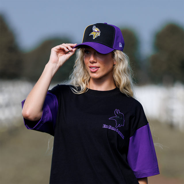 Model wearing the Colour Block New Era Snapback in black and purple, front view