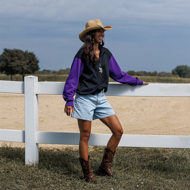 Model wearing the Two-Tone 1/4 Zip Pullover in black and purple at a ranch fence, full-length view