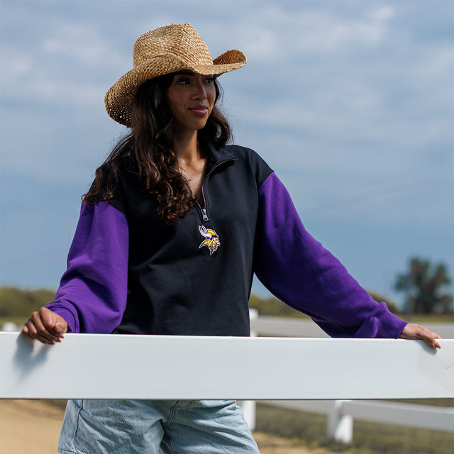 Model wearing the Two-Tone 1/4 Zip Pullover in black and purple, leaning on a white fence