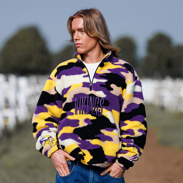 Model wearing the Sherpa 1/4 Zip Pullover in purple and gold camo, front view
