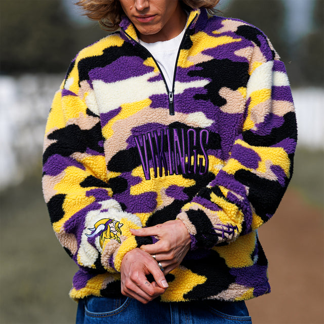 Close-up of the Sherpa 1/4 Zip Pullover in purple and gold camo showing the embroidered Vikings wordmark