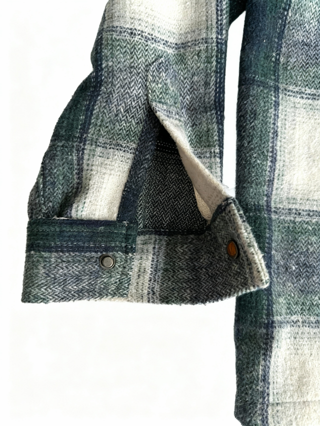 Close-up of a plaid coat with a button on a white background